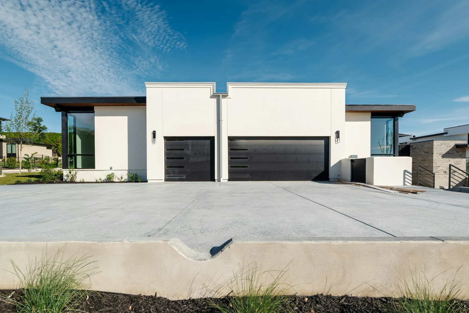 White modern home with a freshly cleaned concrete driveway
