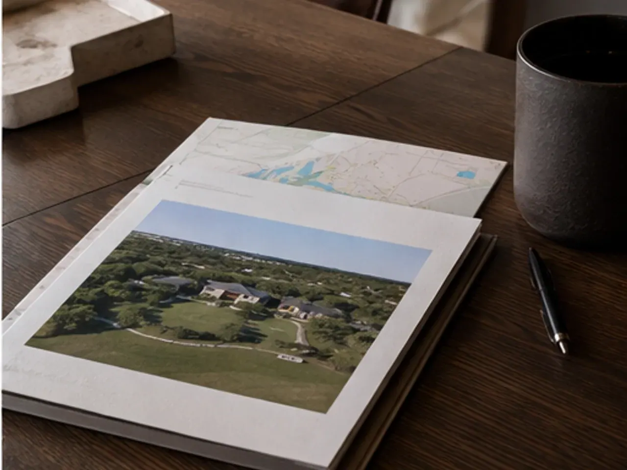 Property dossier with plans and photographs on a desk