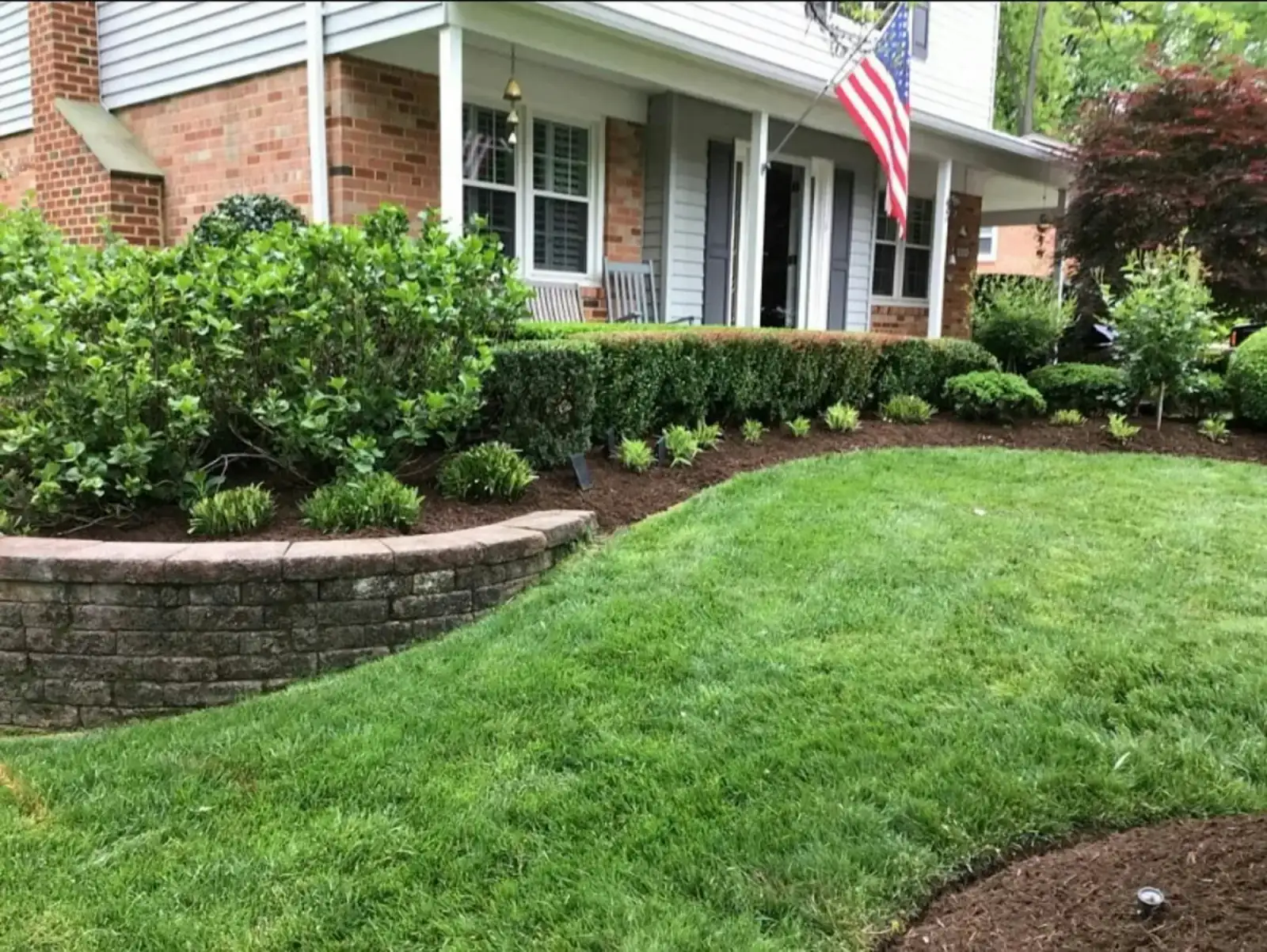 Neatly kept front yard with curved beds and a stone border