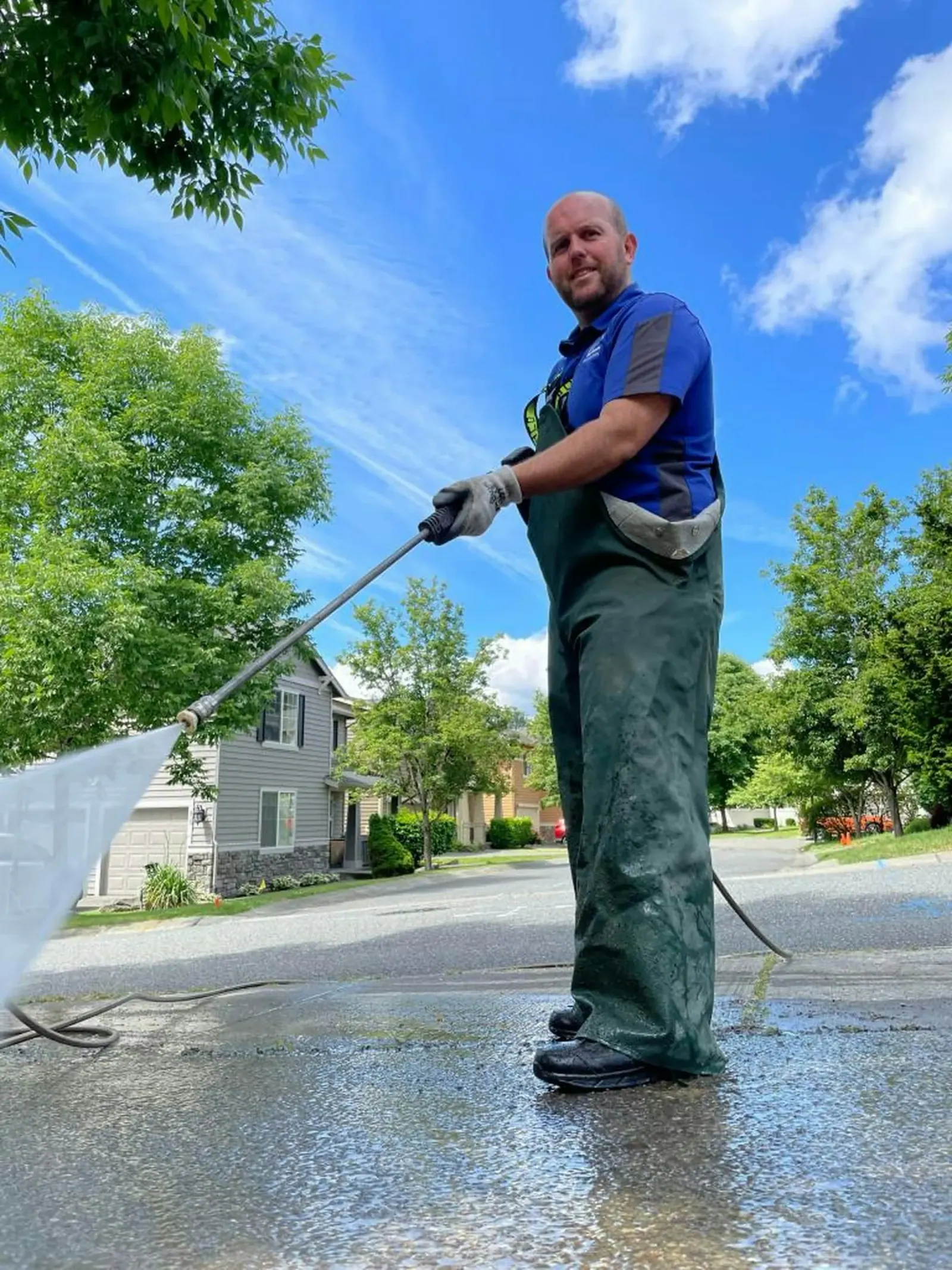 Technician rinsing pavement on a residential street