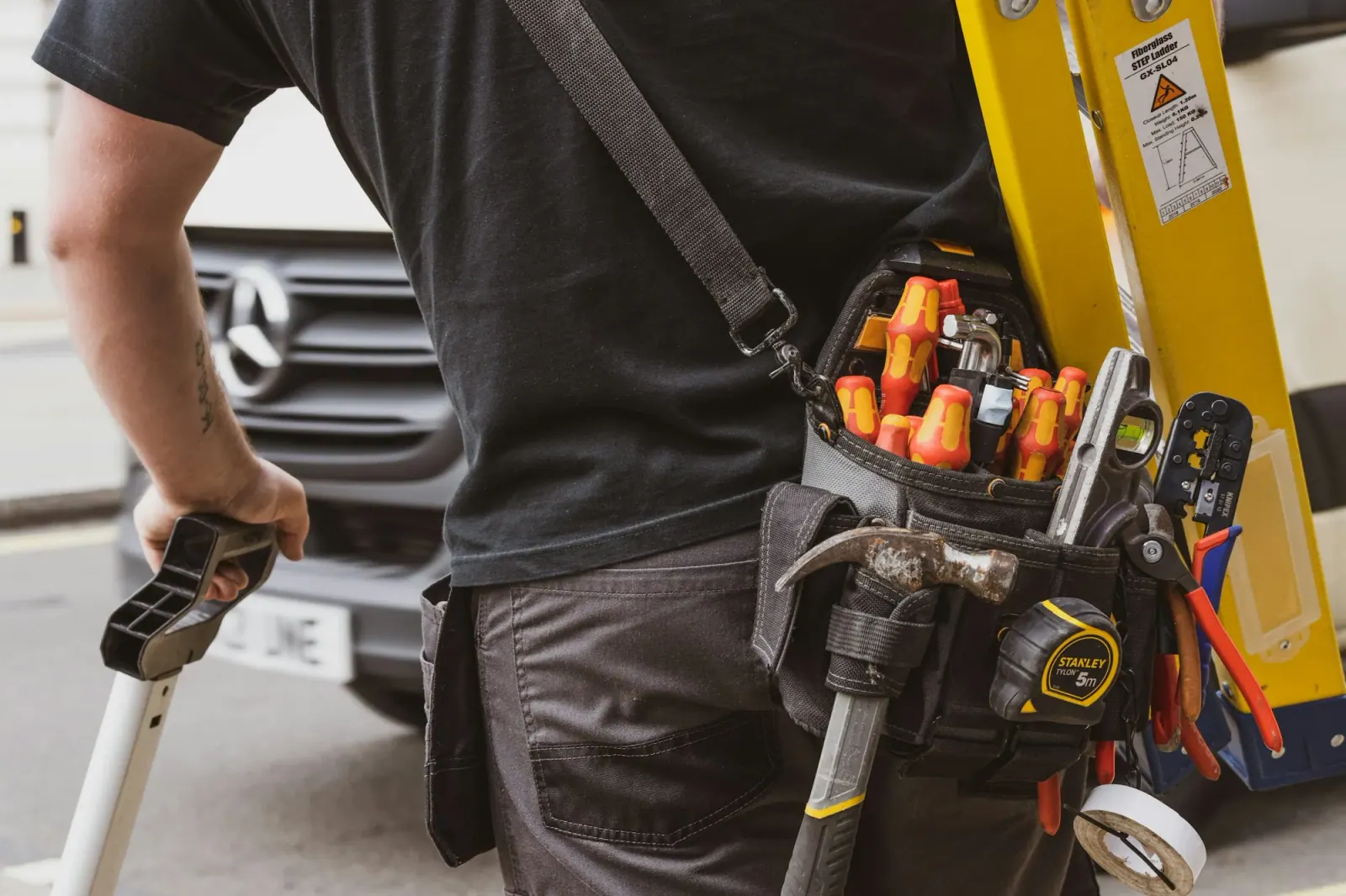 Tool belt loaded with screwdrivers, pliers and a tape measure